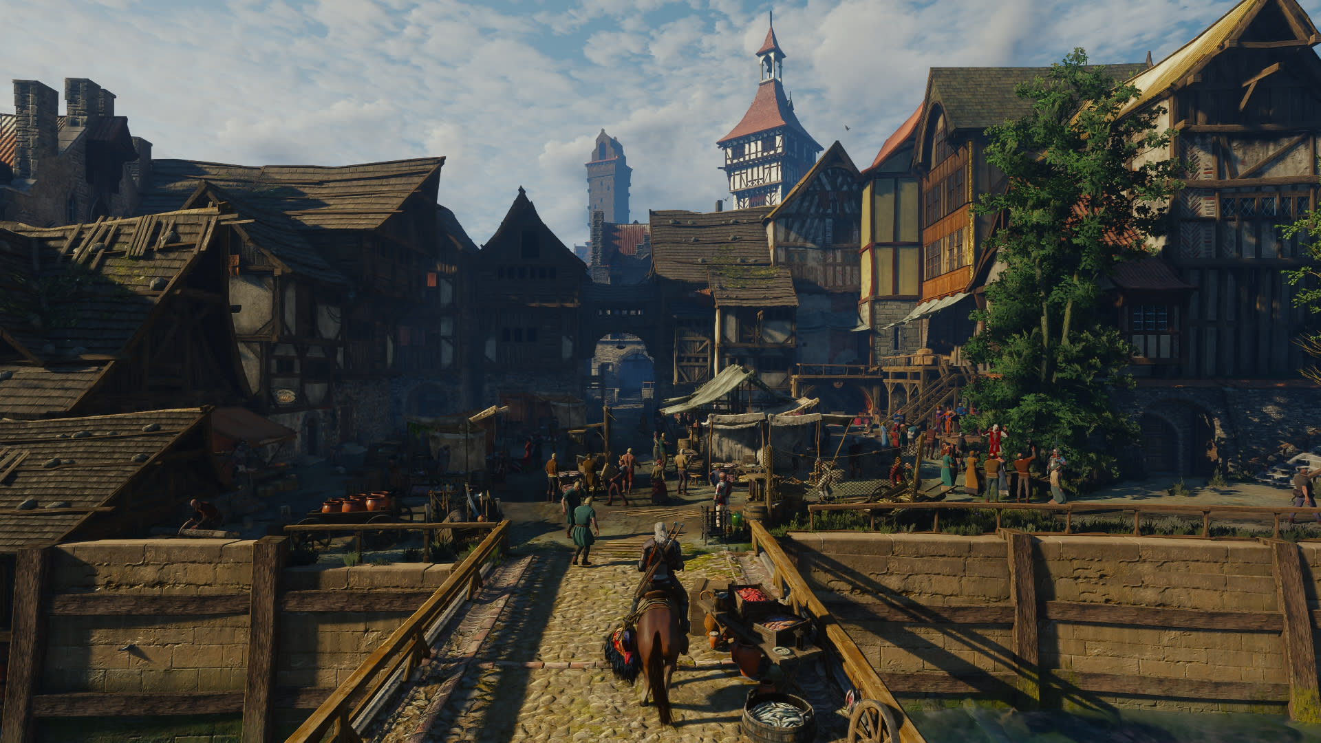 Geralt rides Roach across a bridge into a busy timber-framed town in The Witcher 3: Wild Hunt - Remastered on Nintendo Switch 2